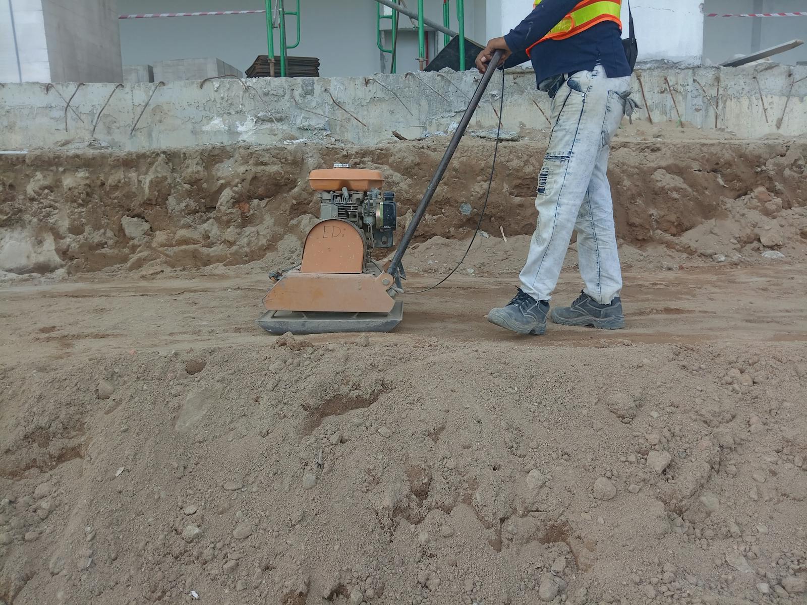 Worker compacting soil for a clean finish